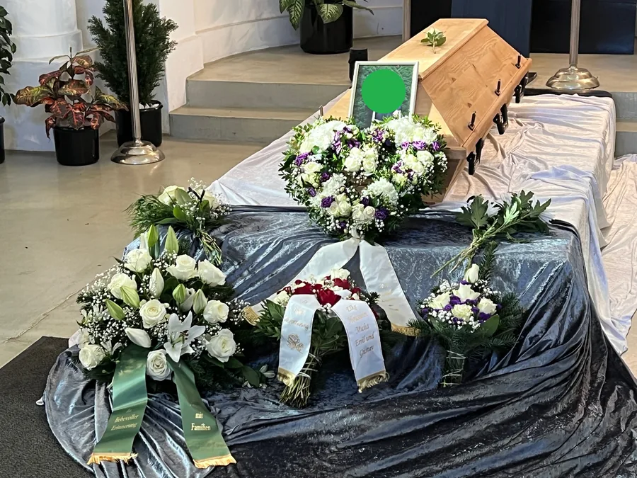 Urne mit Blumen bei einer Trauerfeier