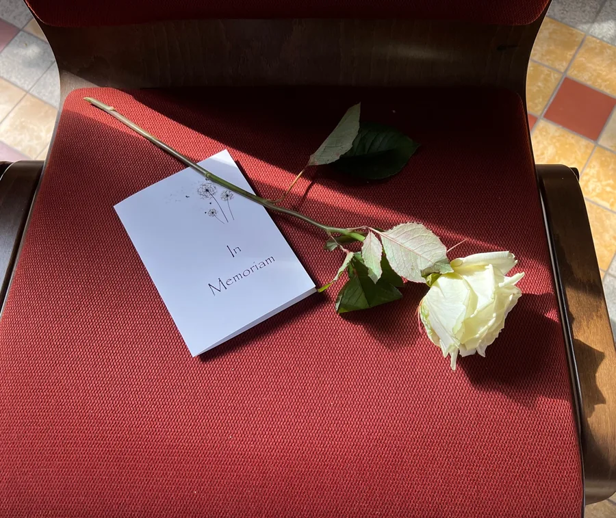 Weiße Rose mit Trauerkarte